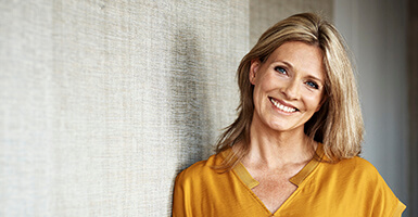 Female in a yellow shirt showing her white teeth