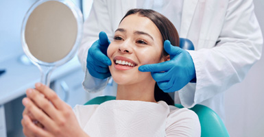 Dental patient checking smile in mirror after dental checkup and cleaning in Odessa