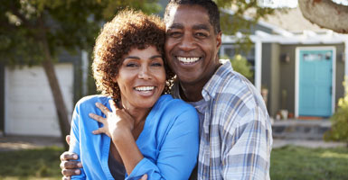 elderly couple smiling on their front porch with dental implants in Odessa