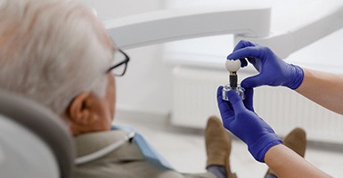 Dentist showing patient a dental implant in Odessa, TX