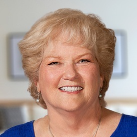 Woman in blue shirt showing her pearly whites