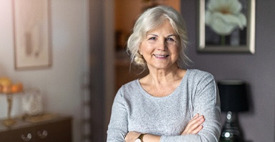 Older woman smiling with her arms crossed