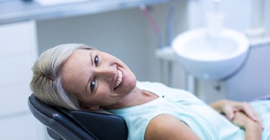 Female dental patient leaning back after getting dental implant in Odessa, TX
