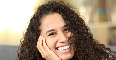 A young woman smiling after completing treatment with Invisalign
