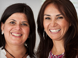 Two long haired women smiling 