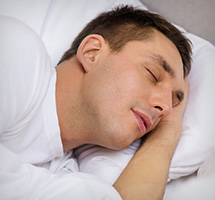 Male lying down in bed peacefully