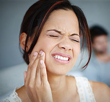 Woman in pain touching her jaw