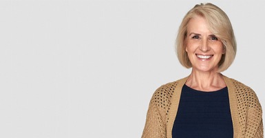 A woman smiling in a brown sweater