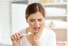 Woman touching her cheek in pain