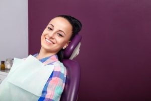 Woman smiling in dental chair seeing cosmetic dentist in Odessa