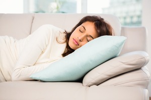 Woman taking a nap on couch with pillows