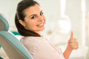 Female dental patient giving thumbs up