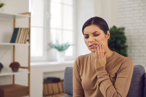 Woman in brown shirt with jaw pain